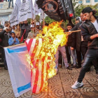 Manifestantes palestinos queman banderas de EEUU e Israel en Gaza.