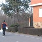 Un joven se dirige hacia su casa portando dos garrafas de agua potable en Nistal de la Vega