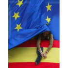 Una funcionaria de la Comunidad de Madrid coloca un crespón negro a una bandera española
