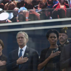 Bush y Obama, acompañados por sus esposas participan en el acto protegidos por un cristal blindado.