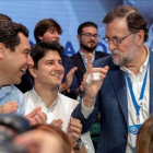 Mariano Rajoy habla con el líder del PP andaluz, Juanma Moreno, y el presidente de Nuevas Generaciones, Diego Gago, en la convención de Sevilla.