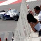 Dos espectadores contemplan desde una terraza el paso de los monoplazas, en este caso el de Heidfeld