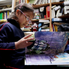 Una niña lee un libro en una biblioteca de Colombia