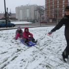 Dos niños juegan junto a su madre en uno de los parques del centro de Ponferrada.
