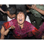 Una mujer, familiar de un pasajero del vuelo MH370, rompe a llorar en el aeropuerto de Kuala Lumpur, este miércoles.