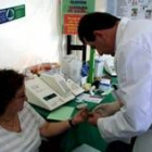Una mujer se mide la glucosa en la sangre en una farmacia