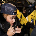Justin Bieber, protegido por la policía, rodeado de fans a su llegada a la comisaría en Toronto.