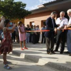 Dos niños fotografían a Álvarez, Llorente y Martínez cortando la cinta inaugural.