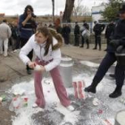 Un policía le da una patada a una caja de leche ante una manifestante ante la fábrica de Lactiber