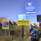 Un peregrino se detiene al llegar a Sahagún junto a las señales de los albergues. ACACIO