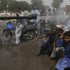 Voluntarios pulverizan a la gente en Karachi.