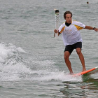 La antorcha olímpica surfea en las playas de Río.