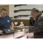 Un hombre inspecciona un arma de fuego en una tienda especializada de Estados Unidos.