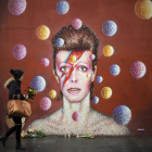 Flores ante un mural de David Bowie en la pared del comercio Morley, en Brixton (Londres), lugar de nacimiento del cantante.