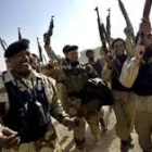 Soldados iraquíes alzan sus fusiles tras la restauración de la seguridad en la frontera de Kusaiba