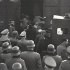 Centenares de ciudadanos judíos suben a trenes con destino a campos de concentración ante la vigilancia de militares nazis.