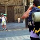 En la imagen, dos turistas de paso por León se fotografían delante del pórtico de la Catedral