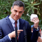El presidente Pedro Sánchez quitándose la mascarilla para comparecer ante los periodistas en Mallorca. BALLESTEROS