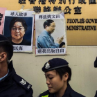 Unos policías frente a las fotos de Gui Minhai (izquierda) y otro de los cinco libreros, Yau Wentian, que fue condenado a 10 años de prisión en el 2015.