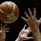 Dos jugadores disputan una pelota de baloncesto.