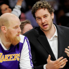 Pau Gasol, de baja, conversa con Chris Kaman durante el partido contra los Suns.