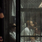 Uno de los detenidos sigue el juicio en una jaula de cristal.
