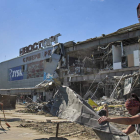 Voluntarios limpian los escombros de un centro comercial destruido por una bomba. SERGEY KOZLOV