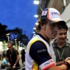 Fernando Alonso, tras su llegada al circuito, recorre el paddock sobre el oscuro cielo de Singapur