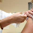 Una enfermera pone una vacuna contra la gripe  a una paciente. ICAL.