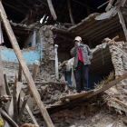Un hombre en pie entre las runas de un edificio destruido por el terremoto de Nepal.