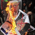 Varios palestinos, contrarios a la decisión de presidente Trump, queman su fotografía y banderas estadounidenses.