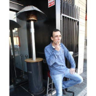 Fumando junto a un calefactor a la puerta de un café.