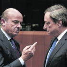 El ministro de Economía español, Luis de Guindos, y el presidente del BCE, Mario Draghi, durante una reunión del Eurogrupo.