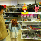 Una madre y un niño miran disfraces en una tienda.