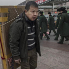 Un hombre llega con un gran televisor en la espalda a la estación central de Pekín, dispuesto a tomar un tren, el 26 de enero.