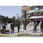 Varios policias inspeccionan la escena de crimen donde exploto una bomba en un mercado popular del barrio Nuevo Bagdad