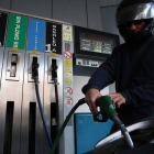 Un motorista pone combustible en una gasolinera.