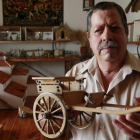 Félix Morán, en el antiguo pajar de su casa, convertido ahora en su museo particular, mostrando un antiguo carro de madera tirado por animales que ha realizado a escala de un original que tenía su padre.
