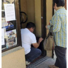 Un hombre limpia el estanco donde tuvo lugar el atraco.