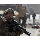 Un soldado norteamericano de la OTAN despeja la zona tras el atentado suicida con coche bomba cometido, hoy, en Kabul.