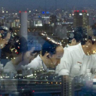Empleados japoneses trabajando a altas horas de la noche en una empresa tecnológica con sede en Tokio.
