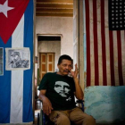 El cubano Armando Ricart Batista, actor y exboxeador, posa ante la bandera cubana y retratos de los Castro en su casa de la Habana.