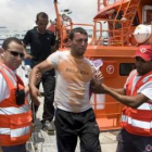 Miembros de Cruz Roja atienden a uno de los inmigrantes a su llegada a Almería.