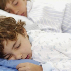 Dos niños en edad escolar durmiendo.