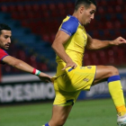 El jugador iraní Ehsan Hajsafí, del Panionios (a la izquierda) disputa el balón con Eyal Golasa, del Maccabi, en el partido disputado en Atenas el pasado día 3.