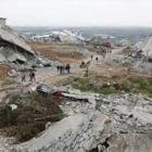 Un grupo de palestinos caminan entre los restos de lo que fueran sus casas.