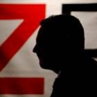 José Luis Rodríguez Zapatero pasa ante un cartel con el logotipo de su campaña