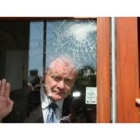 El viceministro, Martin McGuiness, en una ventana golpada por los ataques contra rumanos.