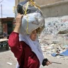 Una mujer palestina traslada en un hatillo algunas de sus pertencias tras abandonar su casa de Rafá