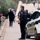 Una patrulla de la Policia impone una multa a dos jóvenes por no llevar mascarilla. JUAN CARLOS CÁRDENAS